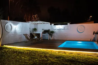 a swimming pool in a backyard at night at MODERNO LUJO in Novo Sancti Petri