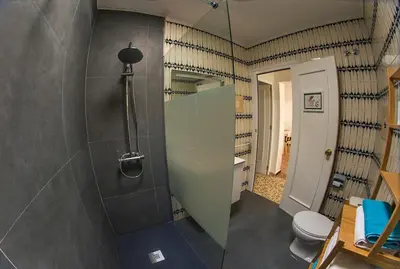 a bathroom with a shower with a toilet and a mirror at Casa Venice in Chiclana de la Frontera