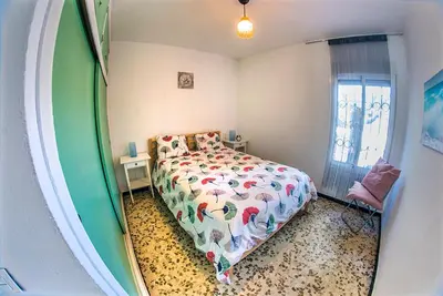 a bedroom with a bed and a window at Casa Venice in Chiclana de la Frontera