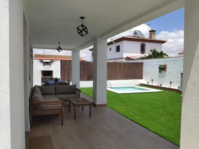a living room with a couch and a green yard at Novoasis in Chiclana de la Frontera