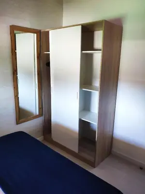 a room with a closet with two mirrors and a bed at Novoasis in Chiclana de la Frontera