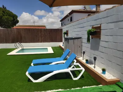 a yard with two lounge chairs and a swimming pool at Novoasis in Chiclana de la Frontera