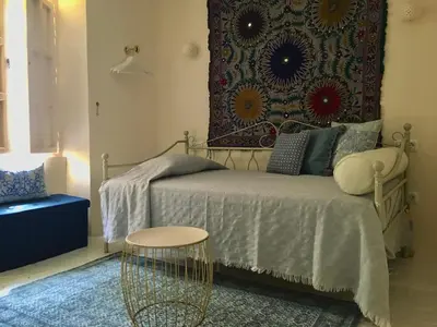 a small bedroom with a bed and a rug at Número 9 in Medina Sidonia