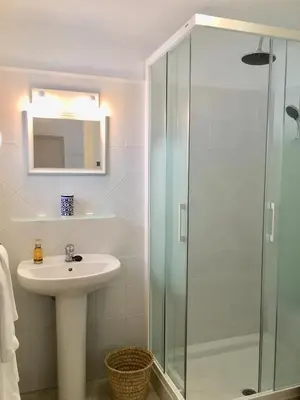 a bathroom with a sink and a glass shower at Número 9 in Medina Sidonia