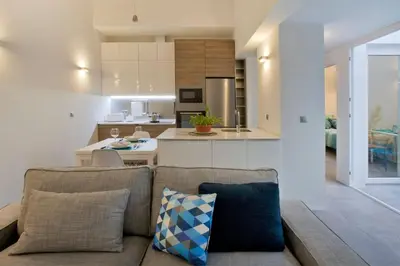 a living room with a couch and a kitchen at GATU Villa Alameda in Cádiz