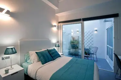 a bedroom with a bed and a room with a balcony at GATU Villa Alameda in Cádiz