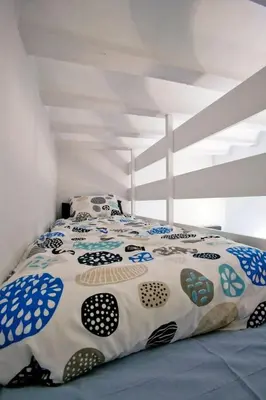 a bedroom with a large bed with a white and blue comforter at GATU Villa Alameda in Cádiz