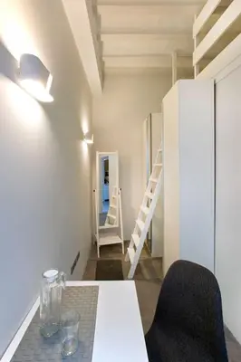 a room with a table and chairs and a staircase at GATU Villa Alameda in Cádiz