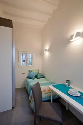 a bedroom with a bed and a desk and a table at GATU Villa Alameda in Cádiz