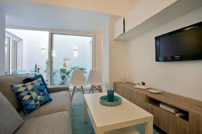 a living room with a couch and a tv at GATU Villa Alameda in Cádiz