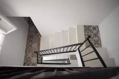 a spiral staircase in a room with tiles on the wall at Apartamento El Tanguillo Little Apartments in Cádiz