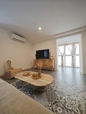 a living room with a coffee table and a tv at Apartamento El Tanguillo Little Apartments in Cádiz