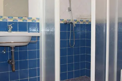 a blue tiled bathroom with a sink and a shower at Chalet La Costa in Chiclana de la Frontera