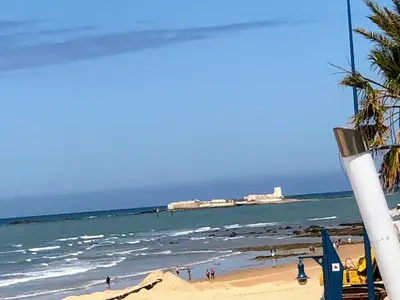 a view of a beach with people in the water at Chalet La Costa in Chiclana de la Frontera