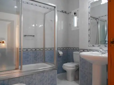 a bathroom with a shower and a toilet and a sink at Apartamento Caracola in Chipiona