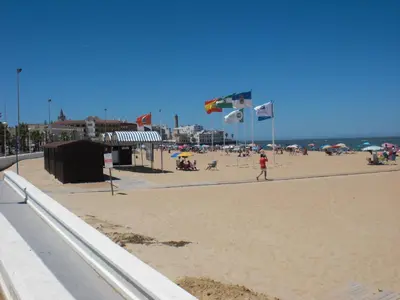 a person flying a kite on the beach at Apartamento Caracola in Chipiona