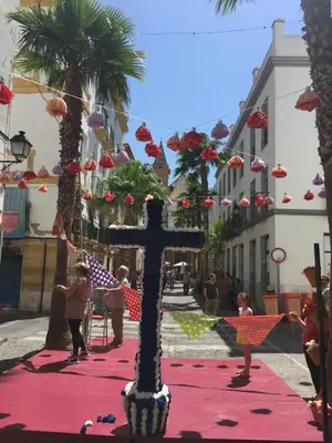a cross on a street with palm trees and people at Apartamento Balneario playa Caleta in Cádiz