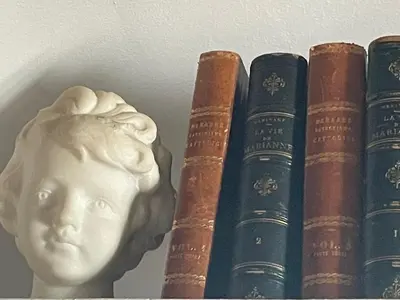 a row of books next to a bust of a head at Casa Antigua - Terraza con Vistas al Mar in Medina Sidonia