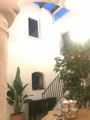 a room with a staircase with plants and a table at Casa Antigua - Terraza con Vistas al Mar in Medina Sidonia