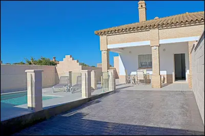 a house with a patio and a swimming pool at Chalet Peñuelas con piscina in Conil de la Frontera