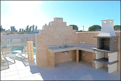 a patio with a sink and a grill on a roof at Chalet Peñuelas con piscina in Conil de la Frontera