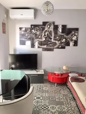 a living room with a table and a tv at Modern Seaside Apartment 700 mt from beach in El Puerto de Santa María