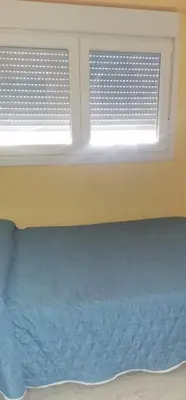 a bed in a room with two windows at Modern Seaside Apartment 700 mt from beach in El Puerto de Santa María