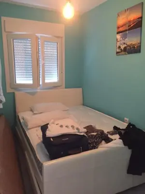 a bed with clothes and a suitcase on it in a room at Modern Seaside Apartment 700 mt from beach in El Puerto de Santa María