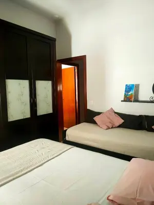 a bedroom with two beds and a door to another room at Apartamento en pleno centro de Cadiz con parking economico in Cádiz