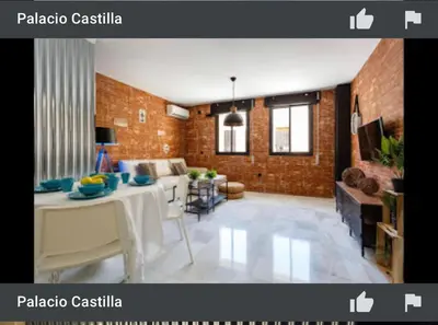 a living room with a table and a brick wall at Apartamento semi-industrial palacio Castilla in Jerez de la Frontera