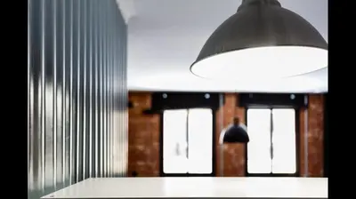 a light hanging over a counter in a room with windows at Apartamento semi-industrial palacio Castilla in Jerez de la Frontera