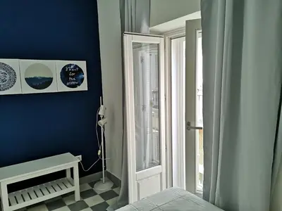 a bedroom with a blue wall and a window at APARTAMENTO APODACA in Cádiz