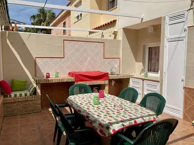 a patio with a table and chairs on a balcony at Casa Valdelagrana Playa in El Puerto de Santa María