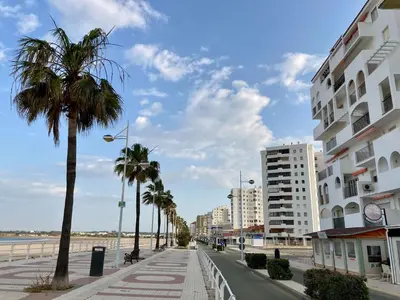 a city street with palm trees and a building at Casa Valdelagrana Playa in El Puerto de Santa María