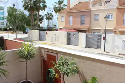 a building with a fence and some trees and buildings at Casa Valdelagrana Playa in El Puerto de Santa María