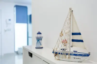 a model boat on a counter with a lighthouse in the background at La Sorpresa del GENOVES by Cadiz4Rentals in Cádiz