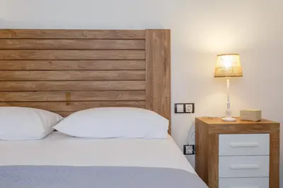 a bedroom with a bed with a wooden headboard at La Sorpresa del GENOVES by Cadiz4Rentals in Cádiz