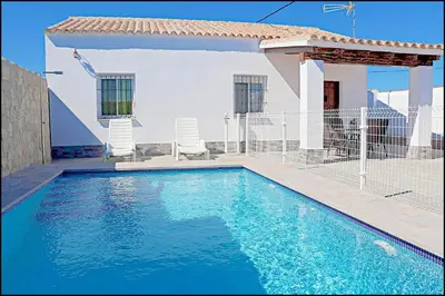 a swimming pool in front of a house at Chalet Ermita in Conil de la Frontera