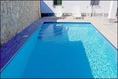 a large blue pool with two chairs in it at Chalet Ermita in Conil de la Frontera