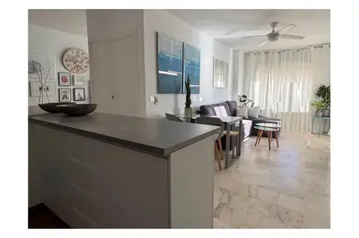 a kitchen and living room with a table and a couch at Romántica vista al paseo marítimo de Cádiz in Cádiz