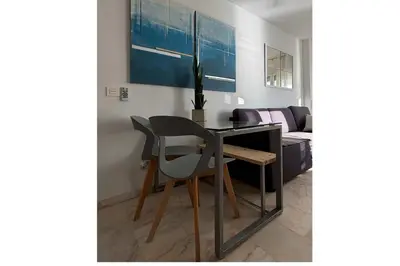 a dining room table with two chairs and a couch at Romántica vista al paseo marítimo de Cádiz in Cádiz