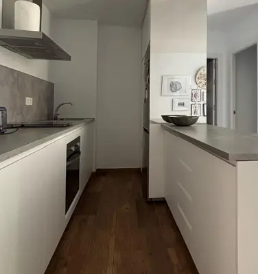 a kitchen with white counters and a wooden floor at Romántica vista al paseo marítimo de Cádiz in Cádiz