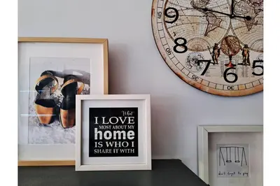 a clock on a wall next to a framed picture at Romántica vista al paseo marítimo de Cádiz in Cádiz