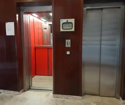 an elevator in a building with red walls and a door at Romántica vista al paseo marítimo de Cádiz in Cádiz