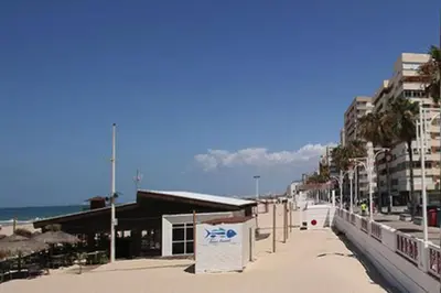 a beach with buildings and the ocean in the background at Romántica vista al paseo marítimo de Cádiz in Cádiz