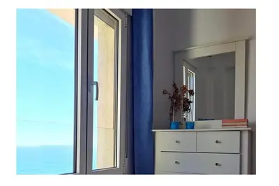 a bedroom with a window and a dresser and a mirror at Romántica vista al paseo marítimo de Cádiz in Cádiz