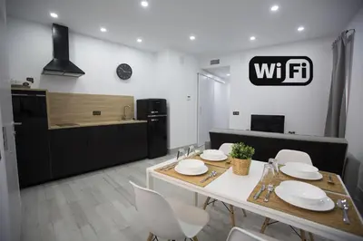 a kitchen and dining room with a table and chairs at Apartamento Centro San Diego in Sanlúcar de Barrameda
