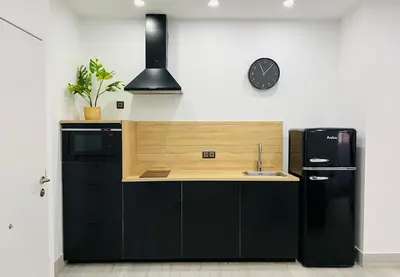 a kitchen with a black refrigerator and a sink at Apartamento Centro San Diego in Sanlúcar de Barrameda