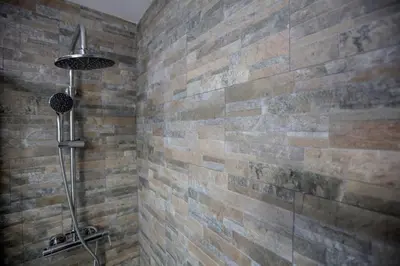 a bathroom with a shower with a brick wall at Apartamento Centro San Diego in Sanlúcar de Barrameda