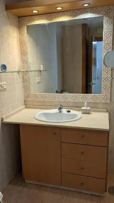 a bathroom with a sink and a large mirror at Apartamento en la playa con garaje in Cádiz